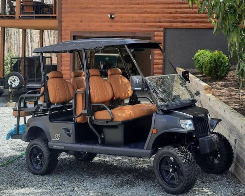 A luxurious black golf cart parked in front of a house, symbolizing status.